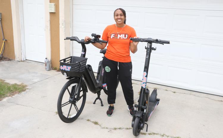 Erica Mayo shows off the e-Fly bike and scooter models that will be used in her upcoming rental business that’ll debut in downtown Lake City in late December. (MORGAN MCMULLEN/Lake City Reporter)