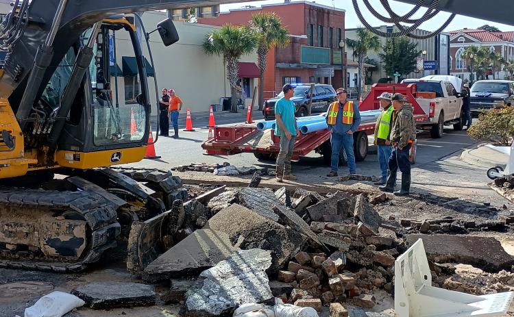 A construction crew takes in the scene above a  ruptured water main in downtown Live Oak. (ROB WOLFE/Lake City Reporter)
