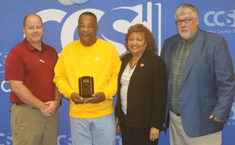 Columbia School District Director of Transportation Daniel Taylor (from left), Clarence Tucker, School Board Member Narri Smith and Superintendent Keith Couey pose after Tucker was honored for saving a student’s life with CPR. (TONY BRITT/Lake City Reporter)