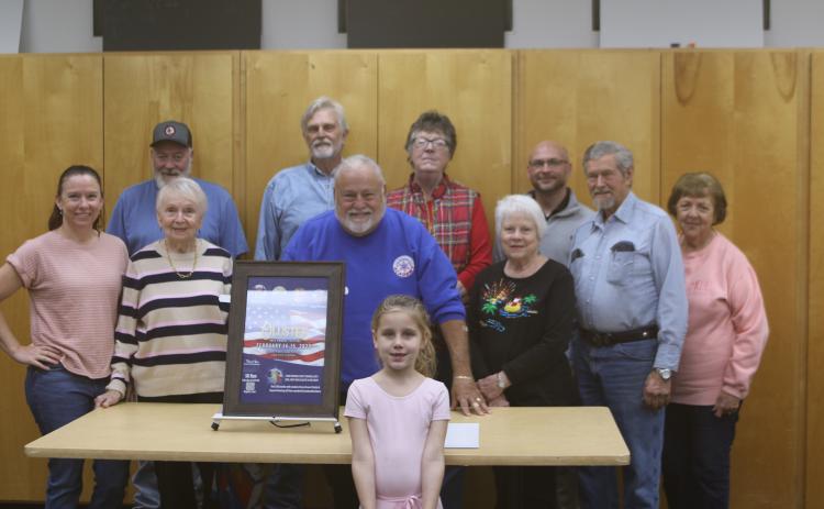 Members of the Blue-Grey Army committee and staff unveiled the 2025 Olusee Festival poster Monday evening at the Columbia County Public Library. Pictured are, in front, Annie Buzzella; second row, from left, Brooke Frye, Faye Warren, Tony Buzzella, Ann Brown; back row, from left, Randy Sweet, Tom Coleman, Patty Melgaard, Matt Johns, Bud Thayer and Ginny Thayer. (TONY BRITT/Lake City Reporter)