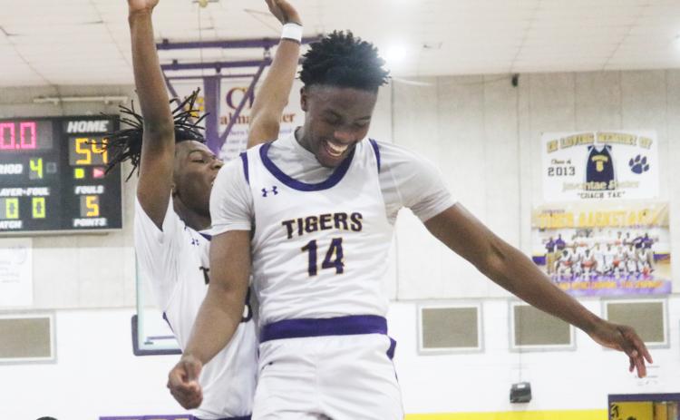 Columbia guard Gavin Broomfield (left) and forward Xavier Collins (14) celebrate after the Tigers rallied from a 13-point deficit to defeat Buchholz 54-49 on Tuesday night. (JORDAN KROEGER/Lake City Reporter)