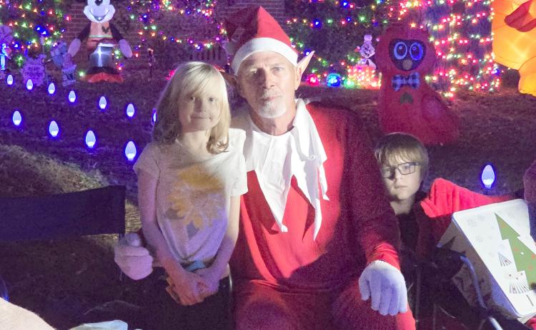 Rocky the Elf is pictured with Evangeline and Rowan McKenna during the special Christmas parade organized for Evangeline, who has been battling cancer for five years. (MONJA SLATER/Lake City Reporter)