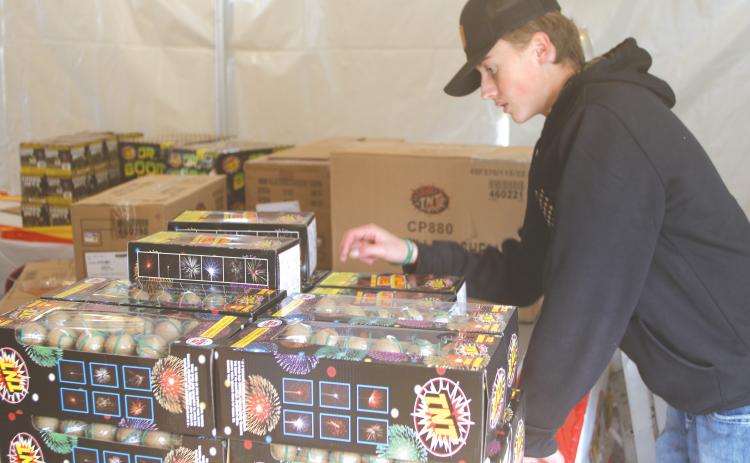 Landon Harper conducts an inventory count on fireworks at the Columbia FFA program’s  fireworks tent. (TONY BRITT/Lake City Reporter)