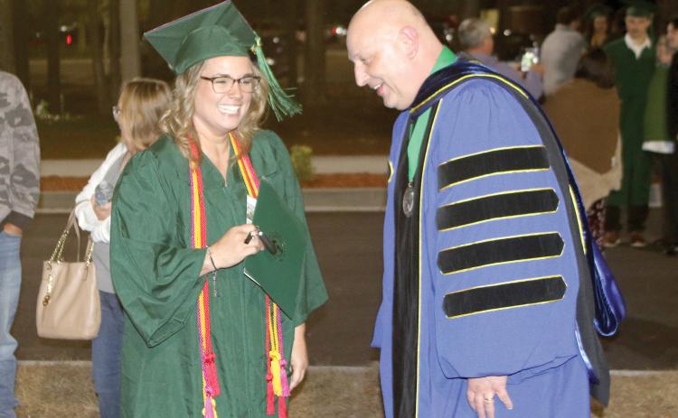 Reba Bridges (left), the student speaker for the Florida Gateway College Fall commencement, shares a laugh with FGC President Lawrence Barrett following the Thursday evening graduation ceremony. (TONY BRITT/Lake City Reporter)