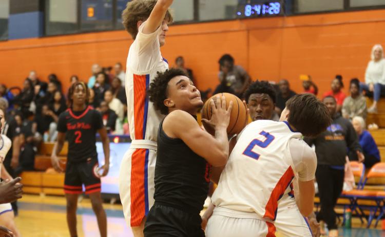 Fort White guard Tafari Moe fights to get off a shot amid the Branford defense on Tuesday night. (PAUL BUCHANAN/Lake City Reporter)