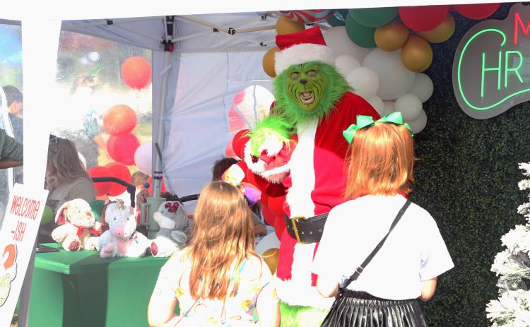 The Grinch speaks with a pair of girls at last year’s Christmas in Columbia Holiday Market. (FILE)