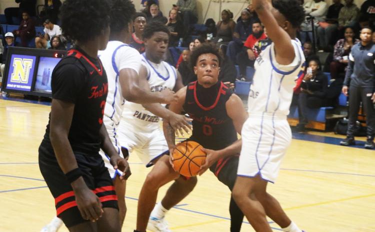 Fort White guard Tafari Moe is bracketed by Newberry defenders during Friday’s 59-45 loss. (MORGAN MCMULLEN/Lake City Reporter)