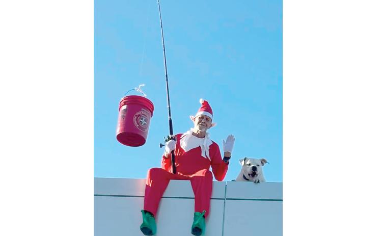 Rocky the Elf (Berry Raulerson) and Mann look out from the roof of Walt’s Live Oak Ford last weekend. (MONJA SLATER/Lake City Reporter)