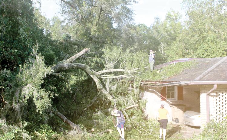 Columbia County residents survey the damage to a home in the wake of Hurricane Helene. Helene made landfall on Sept. 26 before knocking out power for more than 99% of Columbia County residents. (FILE)