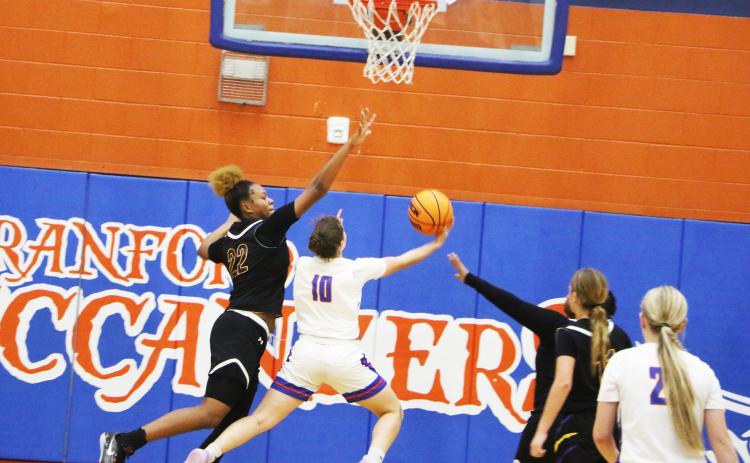 Columbia forward Dariyan Williams goes for a block against Branford guard Cloey Criggall during Monday’s game. (MORGAN MCMULLEN/Lake City Reporter)