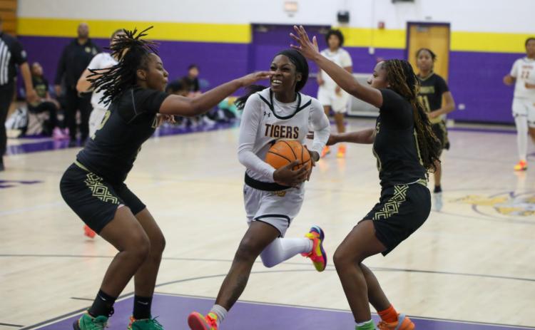 Columbia guard Ayesha Broxey drives to the basket while defended by a pair of Oakleaf players on Tuesday night. (BRENT KUYKENDALL/Lake City Reporter)