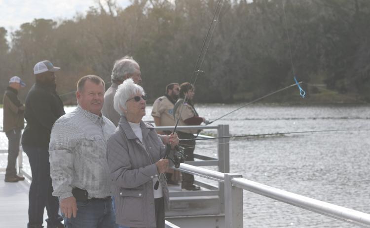 Columbia County Commission Chairman Tim Murphy assists Rose Pavey in casting her line off the new Harter Pier at Lake Montgomery on Friday afternoon. The pier officially opened Friday during a ribbon cutting ceremony. (TONY BRITT/Lake City Reporter)