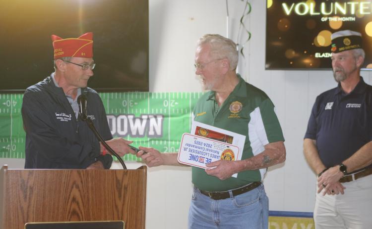 William ‘Bill’ Huggins, American Legion Post 57 Commander, receives mementos from James A. LaCoursiere, the national commander of the American Legion, during his visit to Post 57 on Monday. (TONY BRITT/Lake City Reporter)
