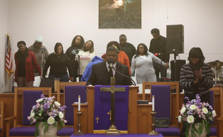 Rev. Jon A. Ingraham, pastor of New Mt. Pisgah AME Church, leads a  prayer during the MLK service on Monday morning. (TONY BRITT/Lake City Reporter)