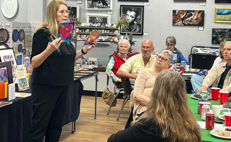 Laura Hunter-Null, a 30-year arts educator, presents some of the artwork and the lessons used in the free art program for students in grades 1-3 to the adult members of the Gateway Art Gallery. (COURTESY GATEWAY ART GALLERY)