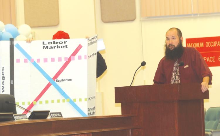 Michael Reynolds gives a presentation to the Columbia County School Board during Tuesday’s meeting on supply and demand of teacher jobs. (TONY BRITT/Lake City Reporter)