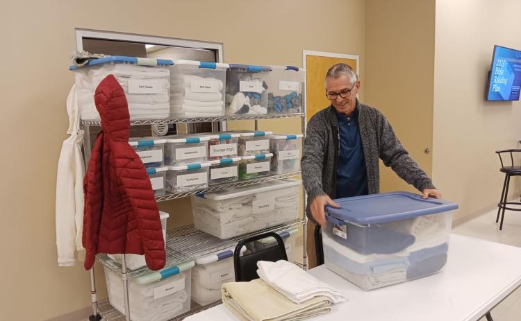 Mike Tatem, Pastor of Parkview Baptist Church, grabs a handful of supplies that will be used in the church’s cold weather shelter on Wednesday before opening the shelter for the evening. (TONY BRITT/Lake City Reporter)