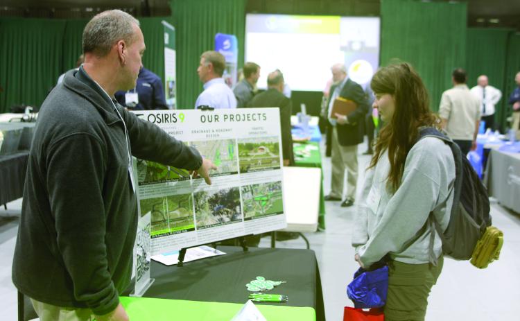 Bryon Wuczynski (left), an Osiris 9 representative, shows a list of recent projects to April Thomas with the Florida Department of Transportation. Osiris 9 helped develop the concept for the U.S. Highway 41 and Interstate 75 interchange project that will be starting soon in Ellisville. (TONY BRITT/Lake City Reporter)