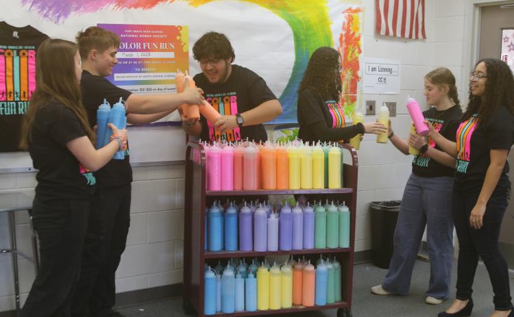 Fort White National Honor Society members Jada Knight (from left), Jack Schroader, Juan Bustamante, Arelis Maldonado, Sarah Heeke and Anais Maldonado prepare and inventory powder for the club’s color fun run which takes place on Saturday at Arrowhead Stadium. (TONY BRITT/Lake City Reporter)