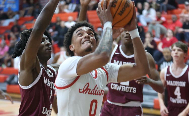 Fort White guard Tafari Moe tries to get off a shot while surrounded by Madison County's defense during Wednesday's Region 3-R semifinal. (PAUL BUCHANAN/Lake City Reporter)