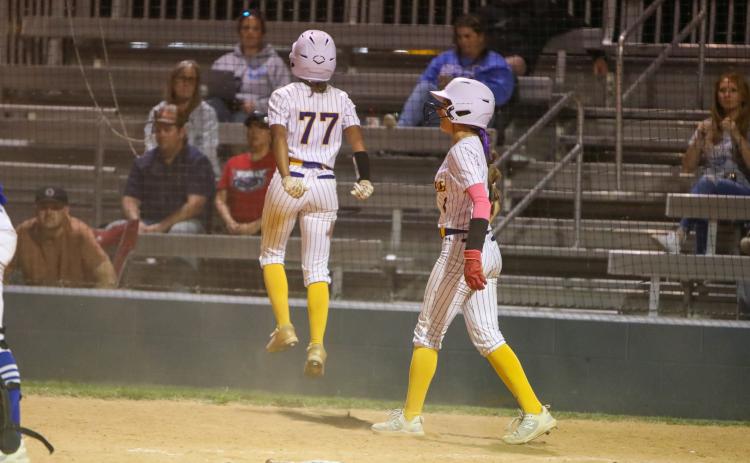 Columbia left fielder Sakiya Merriex jumps after crossing home plate with the game-winning run against Keystone Heights Friday night. Shortstop Lillyenne Mayhew, who had also scored on the play, celebrates alongside Merriex. (BRENT KUYKENDALL/Lake City Reporter)