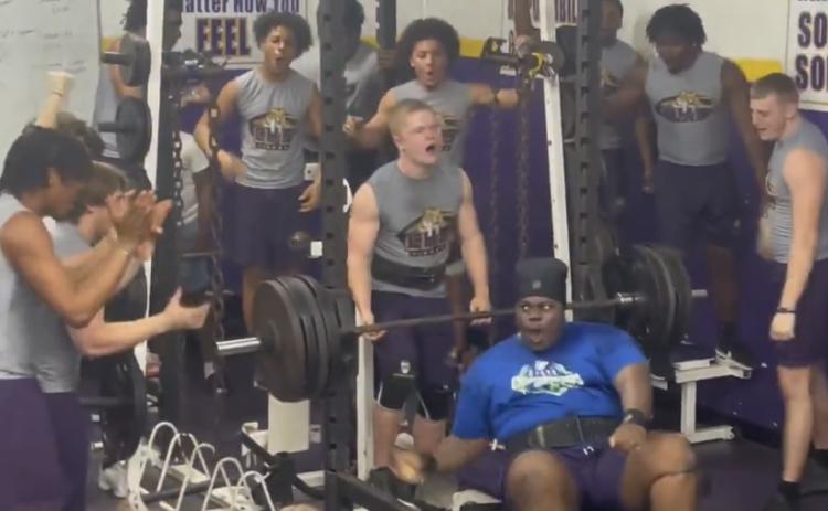 Columbia’s Chase Johnson celebrates with teammates after setting a personal record in the bench press during Wednesday’s meet against Hawthorne. (COURTESY)
