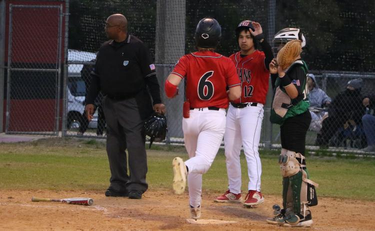 Fort White's Matthew Pitts (6) is greeted at home plate by junior Davic Kasper during Monday's 16-1 win over Ocala Christian. (MORGAN MCMULLEN/Lake City Reporter)