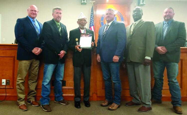 Command Sergeant Major William Smith (third from left) presents a plaque designating Suwannee County as a Purple Heart County to Commissioners Don Hale (from left), Travis Land, Franklin White, Maurice Perkins and Leo Mobley at the board’s March 4 meeting. (COURTESY)