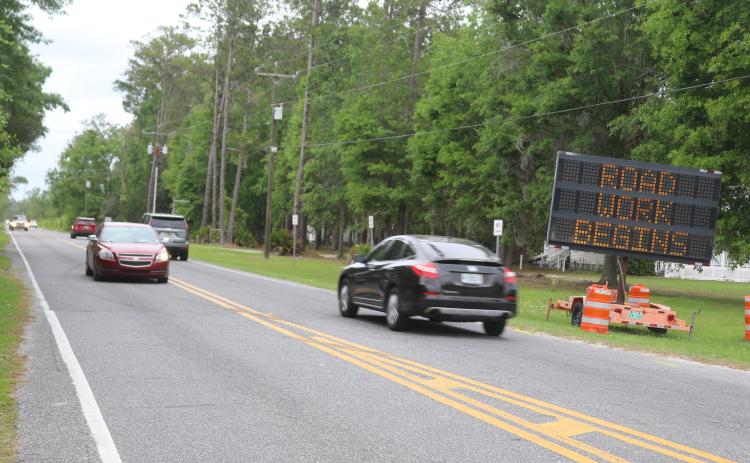 Cars pass a sign on Bascom Norris Drive on Monday warning them of road construction starting on the road, the busiest road maintained by Columbia County. (TONY BRITT/Lake City Reporter)