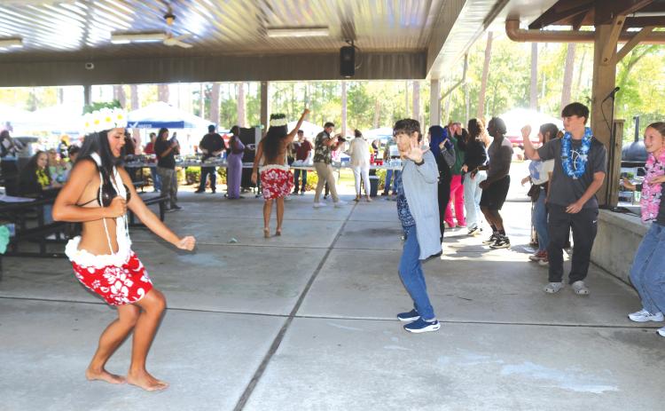 Members of Lana Kalias teach a group of Florida Gateway College students and faculty members how to properly do a Hula dance. (TONY BRITT/Lake City Reporter)