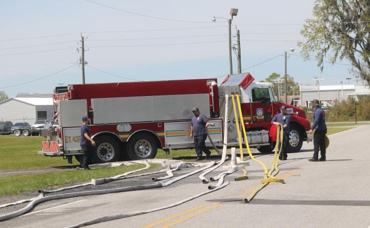 Columbia County Fire Rescue firefighters Joshua Chase, Ryan Jenkins, Cameron McCauley and Blake Heckman inspect a variety hoses as they prepare for a potential busy fire season. (TONY BRITT/Lake City Reporter)