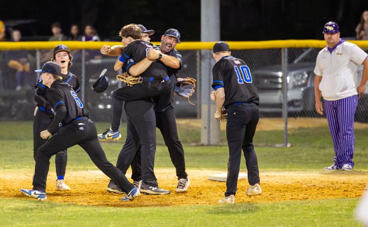 Branford players celebrates with coach Brian Tomlinson after defeating Union County 4-2 in the District 6-R semifinals Tuesday night. (JACK HOWDESHELL/Lake City Reporter)