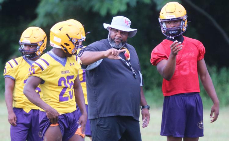 Columbia runnings back coach Quinton Callum (middle) speaks with running back Jerome Horne (left) and quarterback Xavier Collins during Monday’s practice. (JORDAN KROEGER/Lake City Reporter)