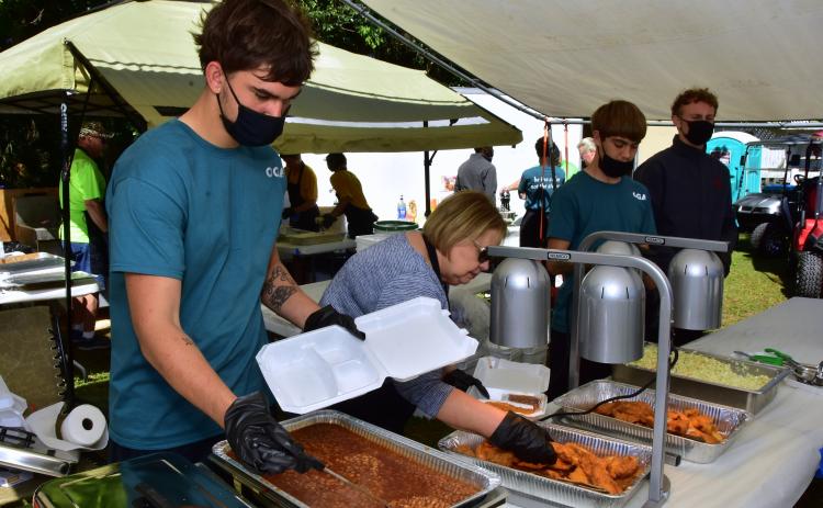 Volunteers serve up catfish dinners at a previous year’s Catfish Festival. The festival, which supports veterans, is set for Saturday at the Branford Greenway. (FILE)