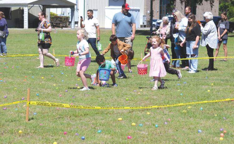 Kids race to gather Easter eggs during the Easter Extravaganza put on by The Canopy at Harper Lake on Saturday afternoon. (TONY BRITT/Lake City Reporter)