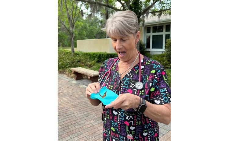 Haven Hospice registered nurse Cindy Romero readies to release one of the butterflies in the Butterfly Memorial Program event Thursday. (COURTESY)