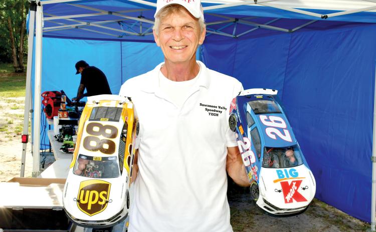 Richard Carroll, the owner of the Suwannee Valley RC Speedway, shows off a pair of the remote control cars that race at the small oval track in Live Oak once a month. (ROB WOLFE/Lake City Reporter)