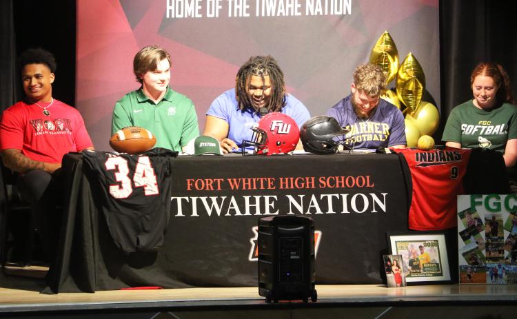 Fort White football players Lecosta Byrd (from left), Kiernen Sheehan, Kingston Anderson, and James Dimauro, as well as softball player Hannah LeBleu, share a laugh during their college signing ceremony on Thursday. Byrd will play at Sussex, Sheehan is headed to Stetson, Anderson signed with Fort Valley State, Dimauro inked with Warner, and LeBleu will suit up for Florida Gateway College. (MORGAN MCMULLEN/Lake City Reporter)