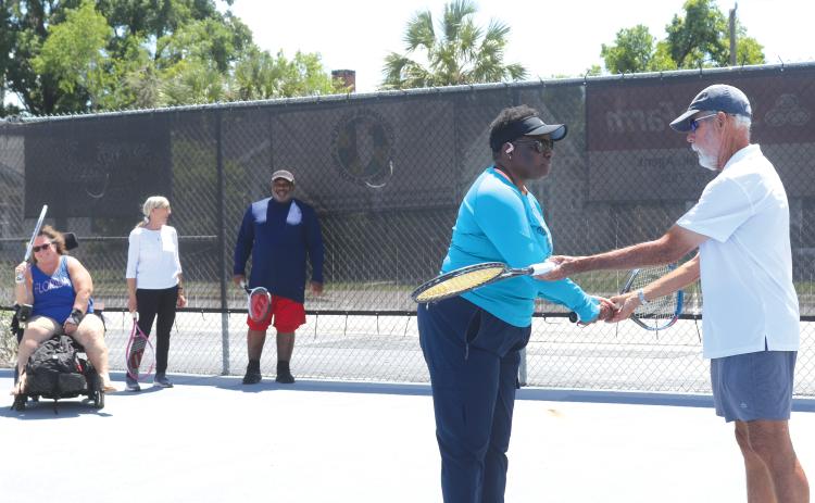 Stacy McCabe gets instructions on her backhand grip from Coach Mark Mansbach, as he teachers McCabe and other veterans the game of tennis through a local program. (TONY BRITT/Lake City Reporter)