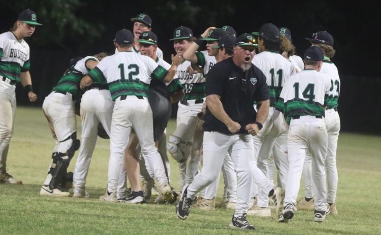 The Suwannee baseball team celebrates with coach Billy Moran out front after the Bulldogs’ 6-5 win over Baldwin in a decisive Game 3 of the Region 1-3A quarterfinals. (MORGAN MCMULLEN/Lake City Reporter)