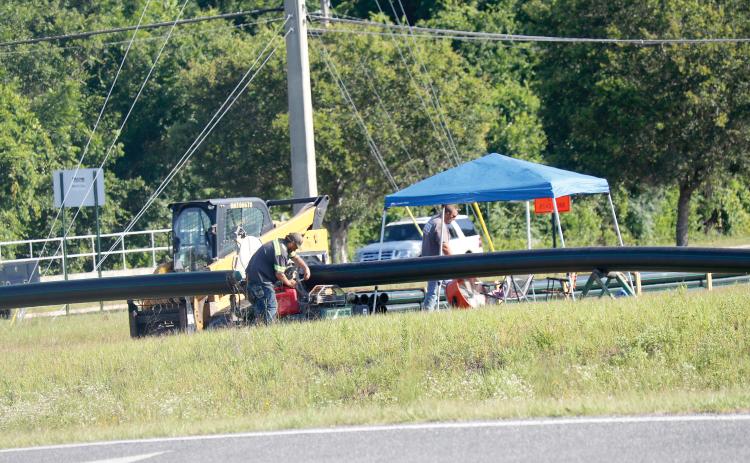 Florida Fill Grading workers work on fusing pipes together on the north side of the State Road 47 and Interstate 75 interchange Friday morning. (JAMIE WACHTER/Lake City Reporter)