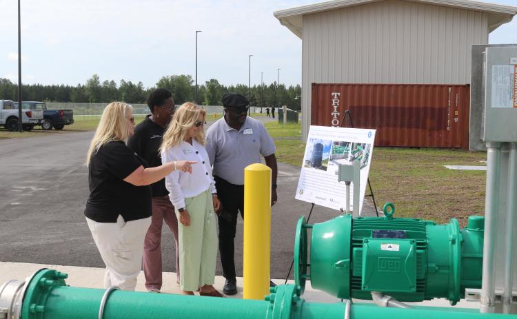 Columbia County Economic Development Director Jennifer Daniels (from left) tells Van Brown and Small Business Administration representatives Tina Davis and Donnie Anderson about tanks and lines at the North Florida Mega Industrial Park wastewater plant during a tour Thursday morning. (TONY BRITT/Lake City Reporter)