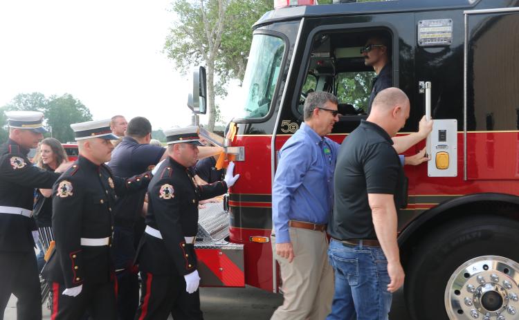 Suwannee County Fire Rescue firefighters and county officials take part in the traditional push-in ceremony Thursday to officially welcome Engine 11 into service for the county’s fire service. (JAMIE WACHTER/Lake City Reporter)
