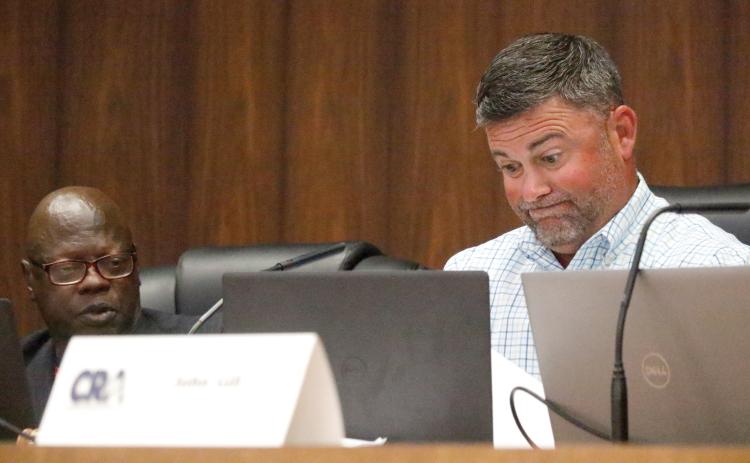 Live Oak Community Redevelopment Agency Chairman Matt Campbell (right) grimaces as he looks over petitions submitted by Board Member Tommie Jefferson (left) in support of a privacy fence around J&W Auto Sales. Jefferson, who collected the petitions on city letterhead, also said during Tuesday’s CRA meeting that he wasn’t seeking any CRA approval. Campbell then asked why was it being discussed at that board’s meeting. (JAMIE WACHTER/Lake City Reporter)