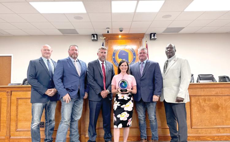 Suwannee County Economic Development Coordinator Charissa Setzer holds the ‘Innovation in Marketing’ award the county’s ‘We are Suwannee’ campaign earned at the Florida Economic Development Council conference last week. She is joined by commissioners Don Hale (From left), Leo Mobley, Travis Land, Franklin White and Maurice Perkins. (JAMIE WACHTER/Lake City Reporter)