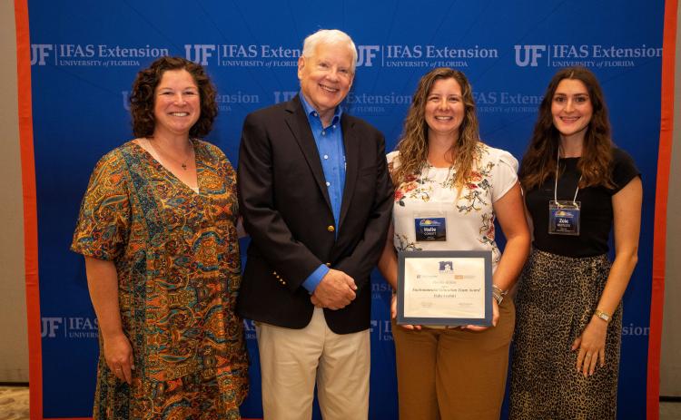 Columbia County UF/IFAS Extension Agent Halie Corbitt (second from right) holds the Environmental Education team award at the 2025 Extension Professional Associations of Florida Symposium. The award went to the Columbia County team, including Heather Futch (left) and Zoie Whitlock (right) as well as Paulette Tomlinson, Erin Harlow, Kalie Picklo, Julia Fulton and the Columbia Master Gardener volunteers. (COURTESY)