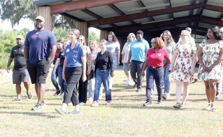 Chris Coleman (from left) and Erin Harlow lead a group of people on a trail tour at Alligator Lake Public Recreation Area on Tuesday morning as part of Economic Development Week activities. (TONY BRITT/Lake City Reporter)