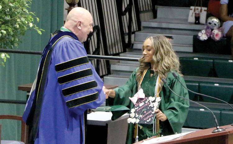 Sakiya Merriex receives her associate in arts degree from Florida Gateway College President Larry Barrett during commencement Thursday at the Howard Center. (MORGAN MCMULLEN/Lake City Reporter)