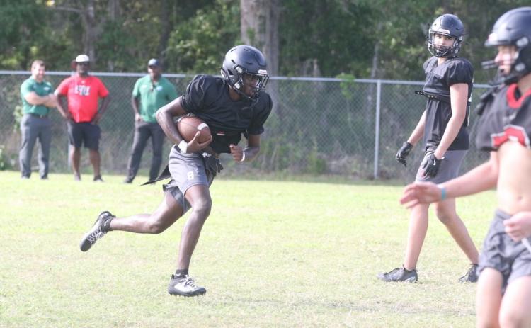 Fort White quarterback Jayden Jackson takes off from the pocket during Thursday’s spring practice. (MORGAN MCMULLEN/Lake City Reporter)