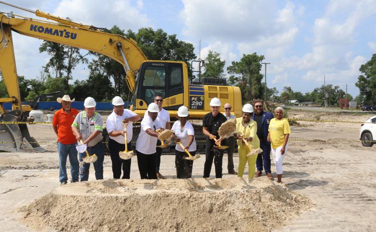Past and current local officials along with affordable housing and construction officials Ron Williams (from left), Everett Phillips, Troy Wimberly, Lester McKellum, Michael Allan, Mary McKellum, Noah Walker, Steve Auger, Chevella Young, James Carter and Tammy Harris pitch shovels of dirt for the ceremonial groundbreaking of the Sweetwater Phase II apartments on Tuesday morning. (TONY BRITT/Lake City Reporter)